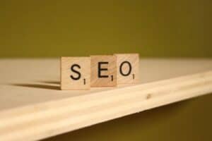 Wooden Scrabble tiles spelling "SEO" on a light wooden surface, representing digital marketing strat.