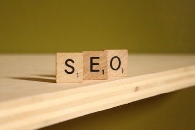 Wooden Scrabble tiles spelling "SEO" on a light wooden surface, representing digital marketing strat.
